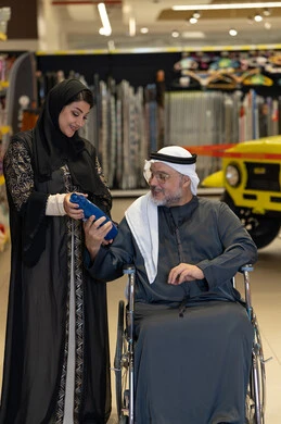 رجل عربي على كرسي متحرك يتسوق في متجر