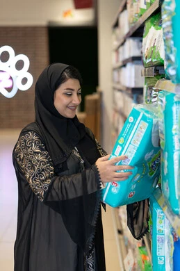 امرأة عربية تتسوق حفاضات الأطفال في السوبر ماركت