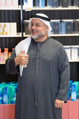 رجل إماراتي يختبر العطور في متجر تجزئة