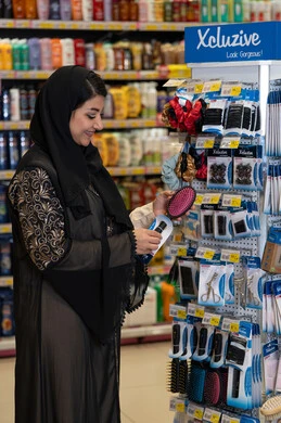 امرأة سعودية تتسوق منتجات التجميل في السوبر ماركت