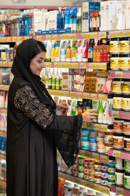 امرأة سعودية تتسوق لمنتجات العناية بالبشرة في الصيدلية