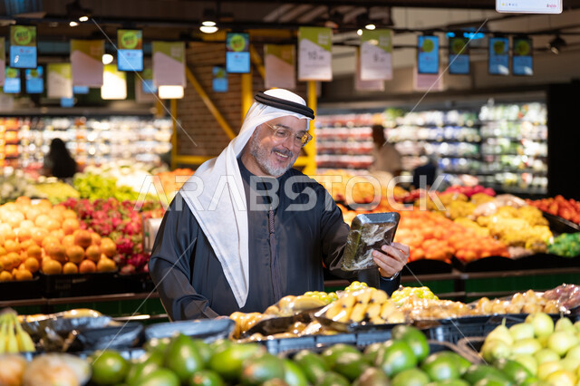 رجل إماراتي يتسوق الخضروات في السوبر ماركت