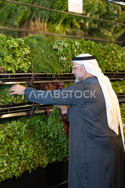 رجل إماراتي يتسوق الخضروات والأعشاب الطازجة