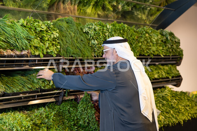Emirati Man Selecting Fresh Herbs in Grocery Market