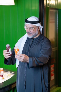 Emirati Man Selecting Fresh Juice Bottles in a Shop Emirati Man Selecting Fresh Juice Bottles in a Shop