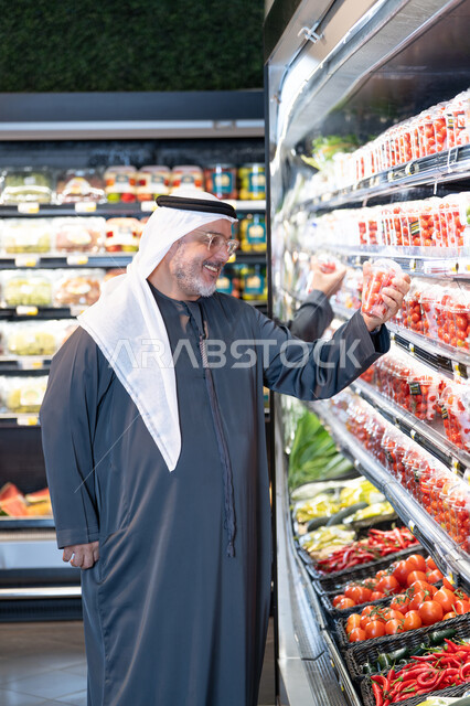 رجل عربي مسن يتسوق الخضروات الطازجة في السوبر ماركت