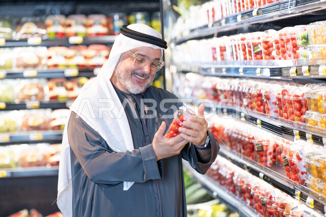 رجل إماراتي يتسوق الخضروات الطازجة في السوبر ماركت