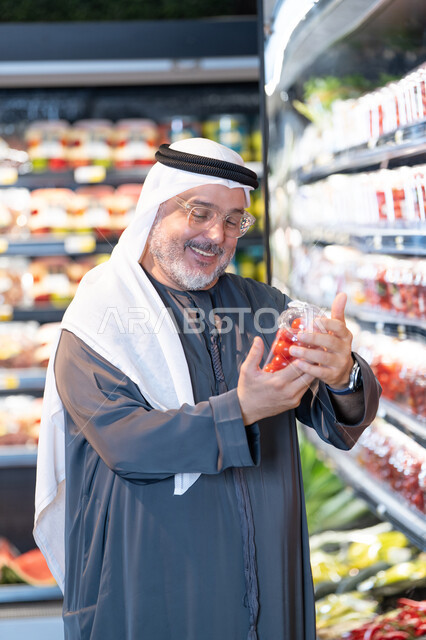 رجل إماراتي يتسوق المنتجات الطازجة في السوبر ماركت