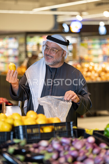 رجل عربي يتسوق لشراء الليمون الطازج في السوبر ماركت