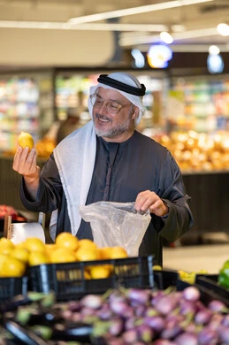 رجل عربي يتسوق لشراء الليمون الطازج في السوبر ماركت