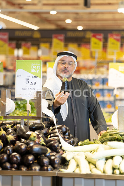 رجل إماراتي يختار الخضروات الطازجة في السوبر ماركت