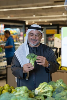 Emirati Man Shopping for Broccoli in Supermarket