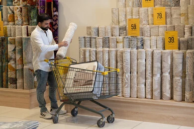 Arab Man Shopping for Carpets in Furniture Store