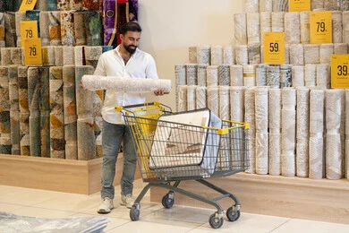رجل عربي يتسوق لشراء السجاد في متجر مفروشات