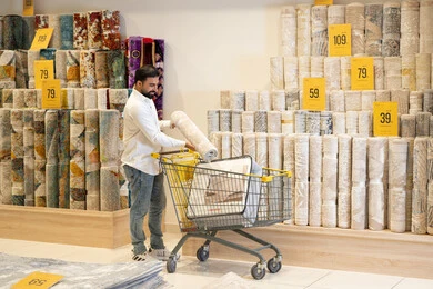 رجل سعودي يتسوق لشراء السجاد من متجر مفروشات منزلية