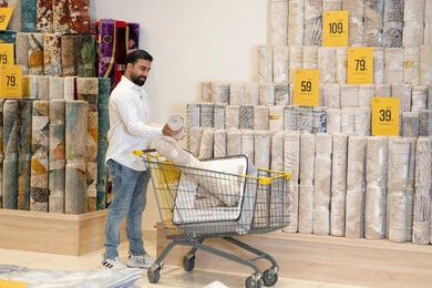 رجل عربي يتسوق لشراء السجاد في متجر ديكور