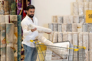 رجل عربي يتسوق لشراء السجاد في متجر ديكور منزلي