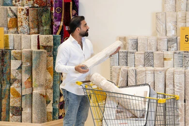 Arab Man Shopping for Carpets in Store Warehouse