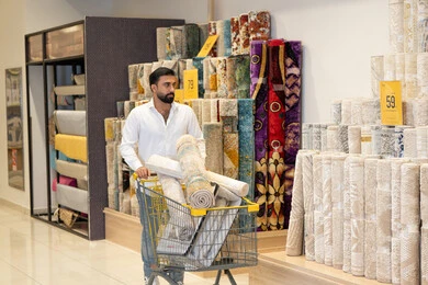 رجل عربي يتسوق لشراء السجاد في متجر أثاث