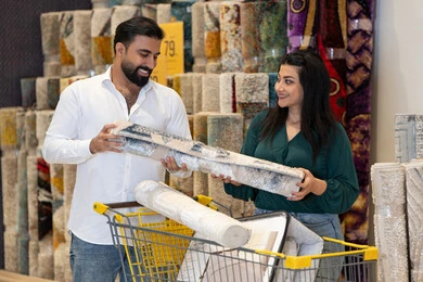 زوجان عربيان يتسوقان لشراء السجاد في معرض أثاث