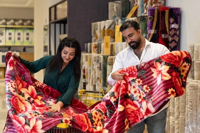 Arab Couple Shopping for Floral Blanket in Home Store