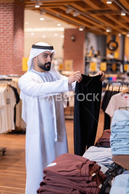 رجل إماراتي يتسوق في متجر ملابس حديث