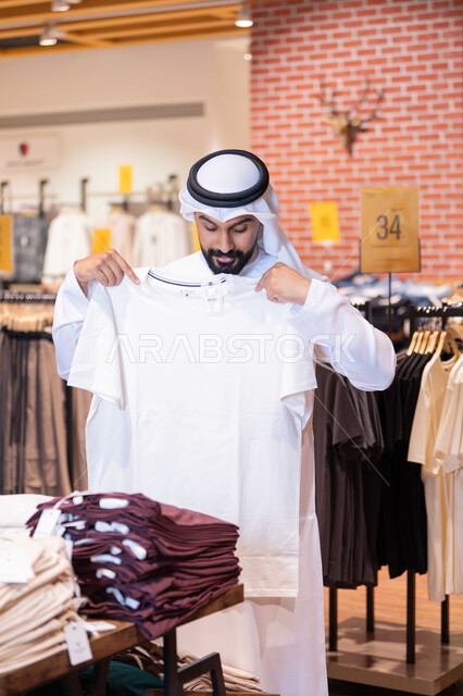 رجل إماراتي يتسوق داخل متجر ملابس