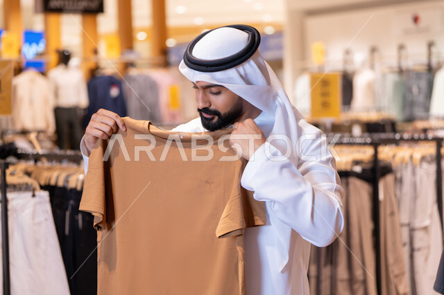 Emirati Man Inspecting Clothes in Retail Store