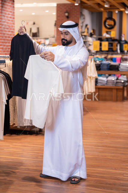 Emirati Man Shopping for T-Shirts in Retail Store