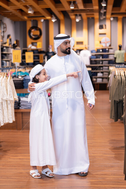 أب وابنه بزي إماراتي في متجر ملابس
