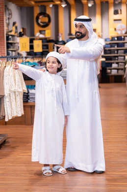 Emirati Father and Son Shopping in Traditional Kandura