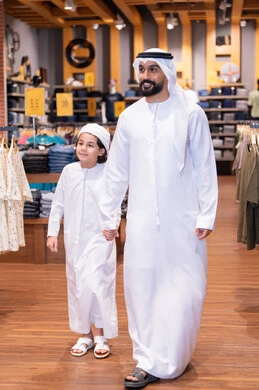 Emirati Man and Boy Shopping in Traditional Clothing Store