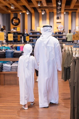 أب سعودي وابنه يتسوقان في متجر ملابس