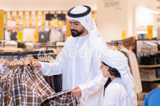 Emirati Man and Boy Shopping for Clothes in Mall