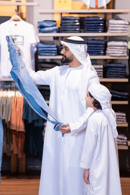Emirati Man and Boy Shopping for Clothes in Mall