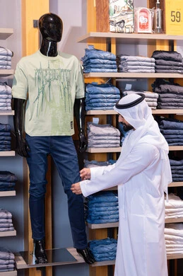 رجل إماراتي يتسوق في متجر ملابس حديث رجل إماراتي يتسوق في متجر ملابس حديث