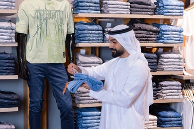 رجل إماراتي يتسوق في متجر ملابس حديث