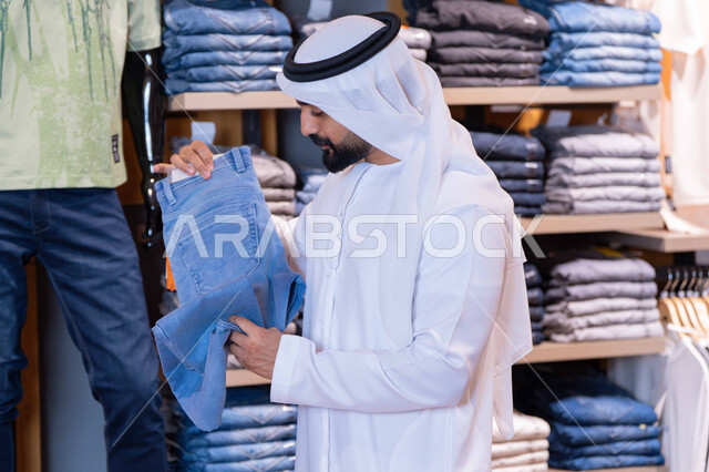 رجل إماراتي يتسوق لشراء الملابس في المتجر