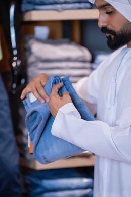 رجل إماراتي يتسوق لشراء الملابس في متجر