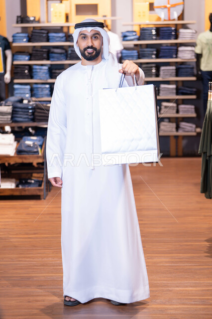 Emirati Man Holding Shopping Bag in Clothing Store