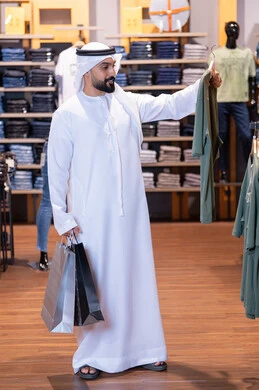رجل إماراتي يتسوق في متجر ملابس حديث
