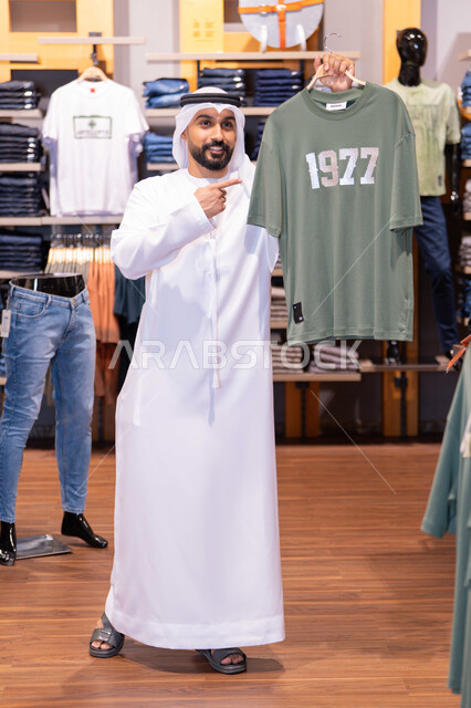 Emirati Man Holding T-Shirt in Clothing Store