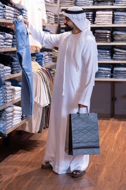 رجل إماراتي يتسوق لشراء الملابس في المتجر