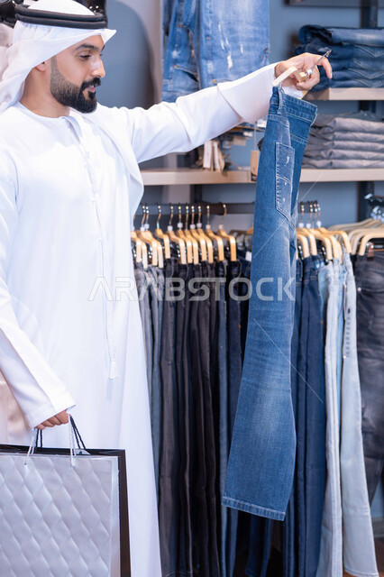Emirati Man Shopping for Jeans in Clothing Store