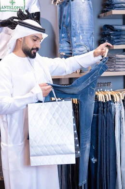 رجل إماراتي يتسوق لشراء ملابس في متجر