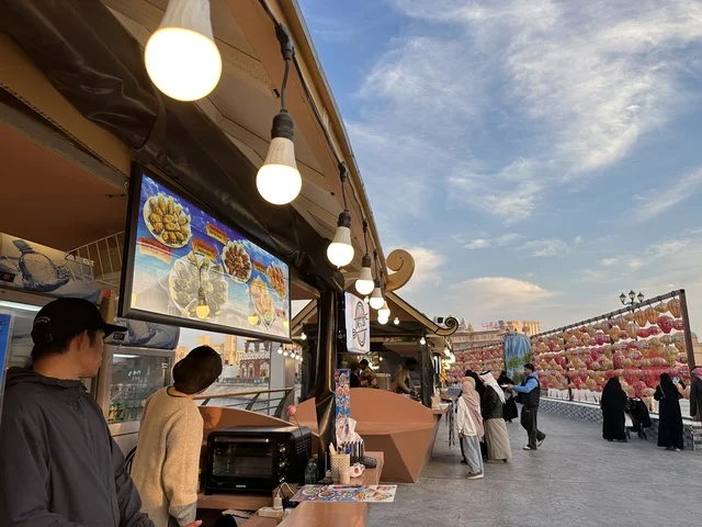 كشك بيع الحلوى والطعام الصيني، تعرف ثقافة البلاد المختلفة، معلم جذب سياحي وترفيهي، تنشيط الحركة السياحية والاقتصادية، المدينة العالمية يناير 2026 على ضفاف الخليج العربي وبحيرة سيهات في المنطقة الشرقية الدمام، مكان لقضاء وقت ممتع مع العائلة