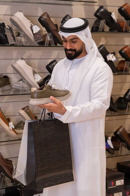 Emirati Man Shopping for Shoes in Retail Store