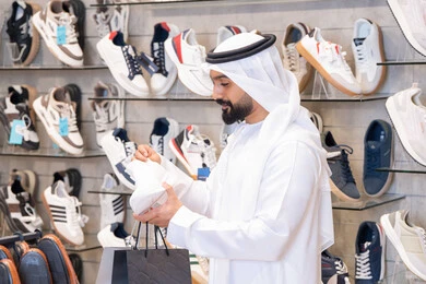 رجل إماراتي يتسوق في متجر أحذية حديث