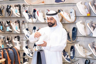 Emirati Man Shopping for Sneakers in Modern Store