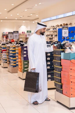 رجل إماراتي يتسوق في متجر أحذية حديث